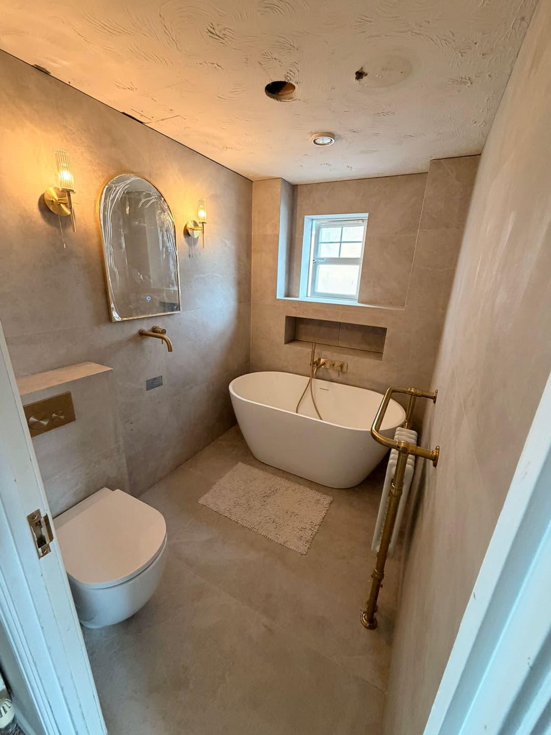 Bathroom with a freestanding bath and brass fittings
