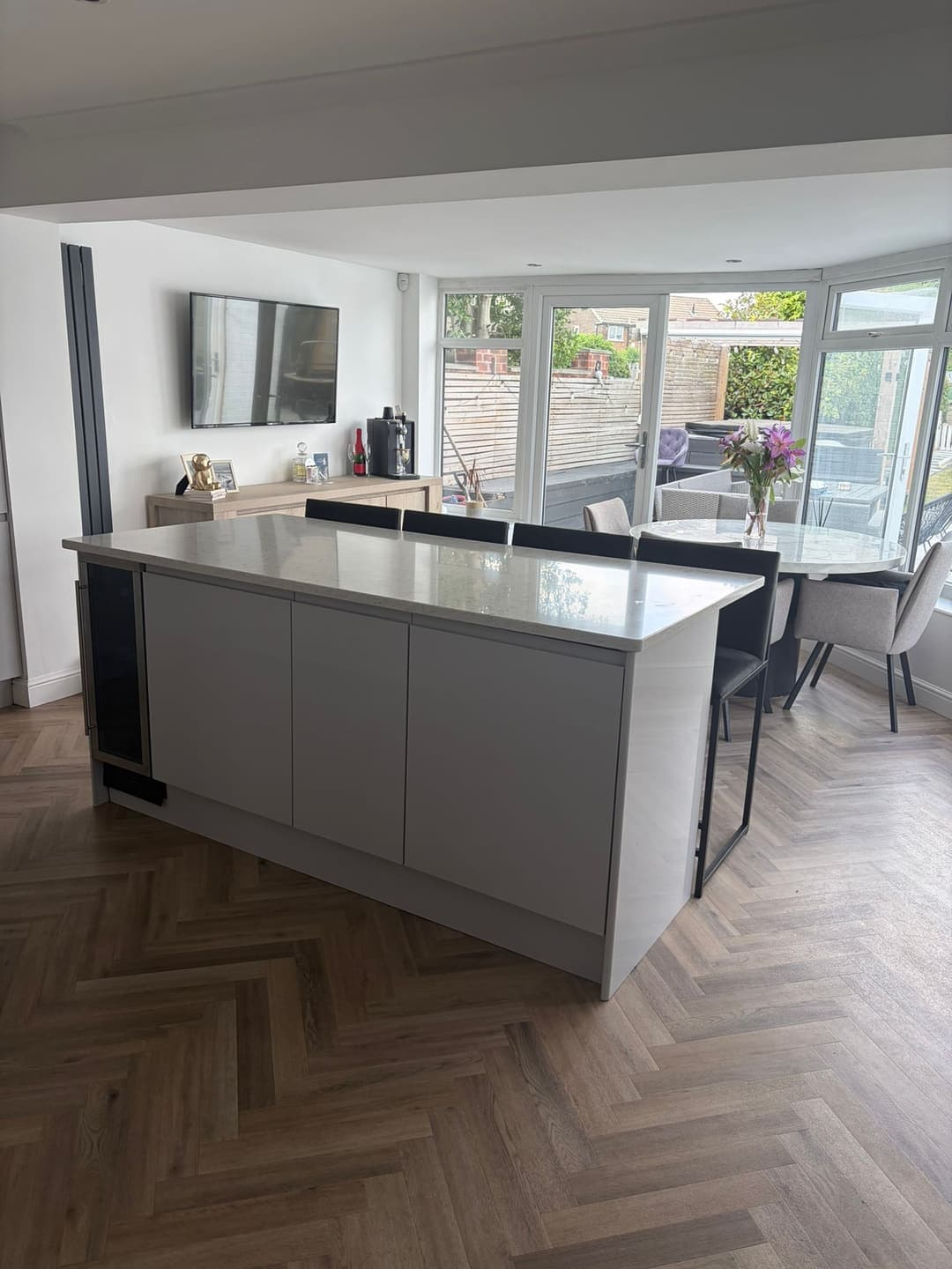 Gloss kitchen with a quartz island and herringbone floor